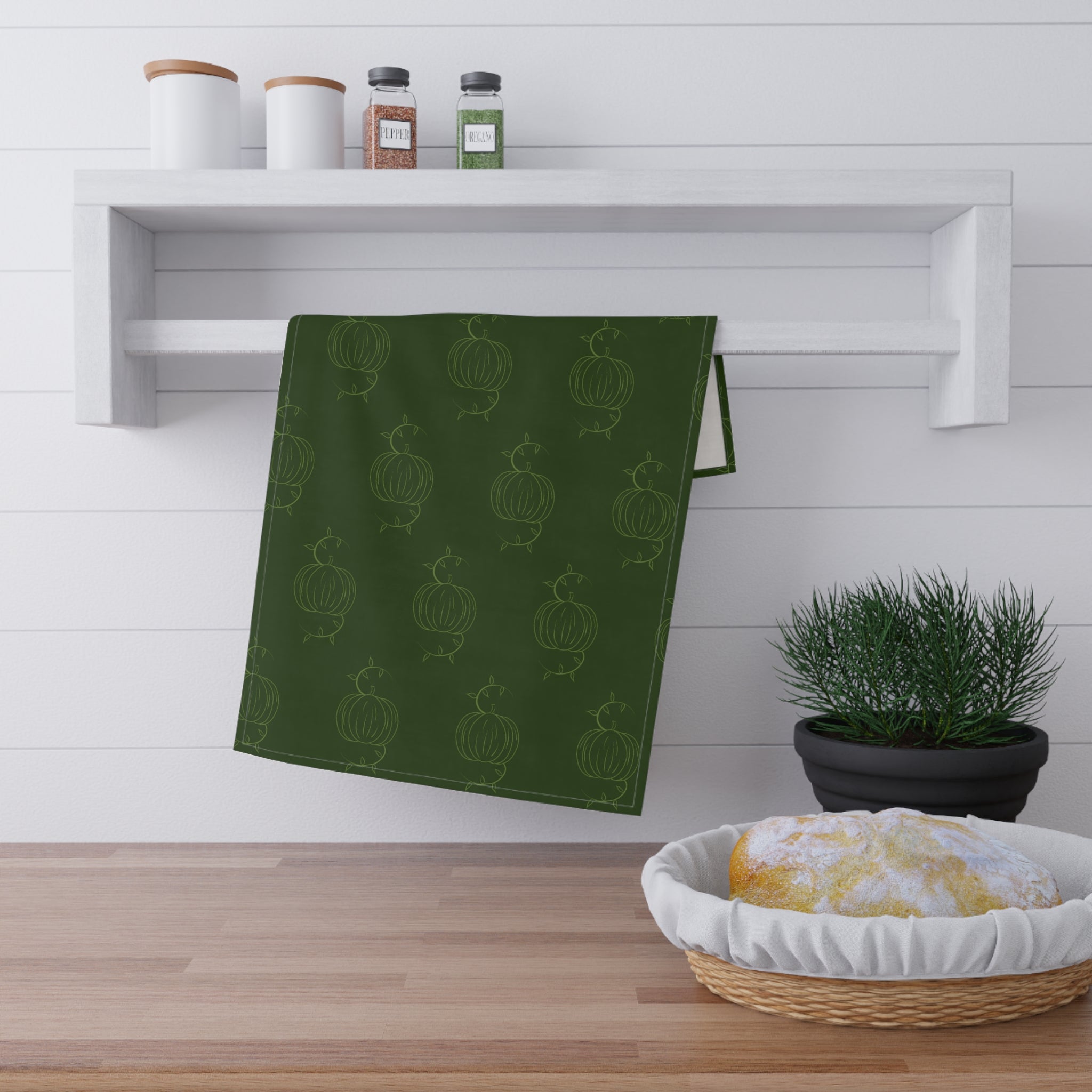 Green tea towel with repeating pumpkin line pattern, folded rectangle