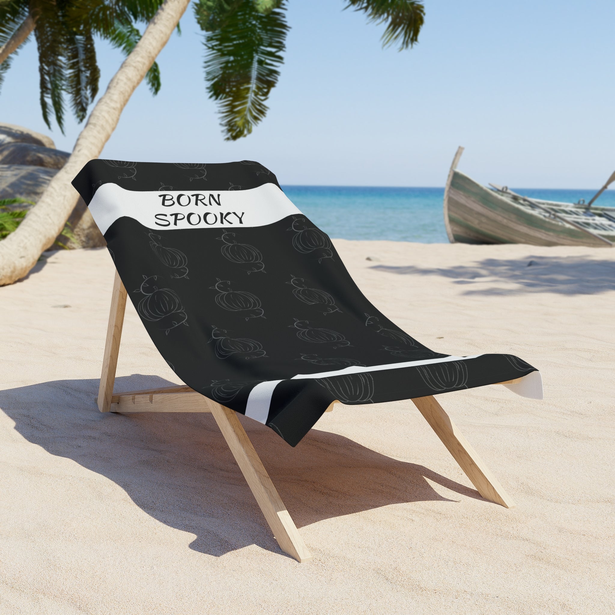 Black towel draped on wooden beach chair with white stripe, &