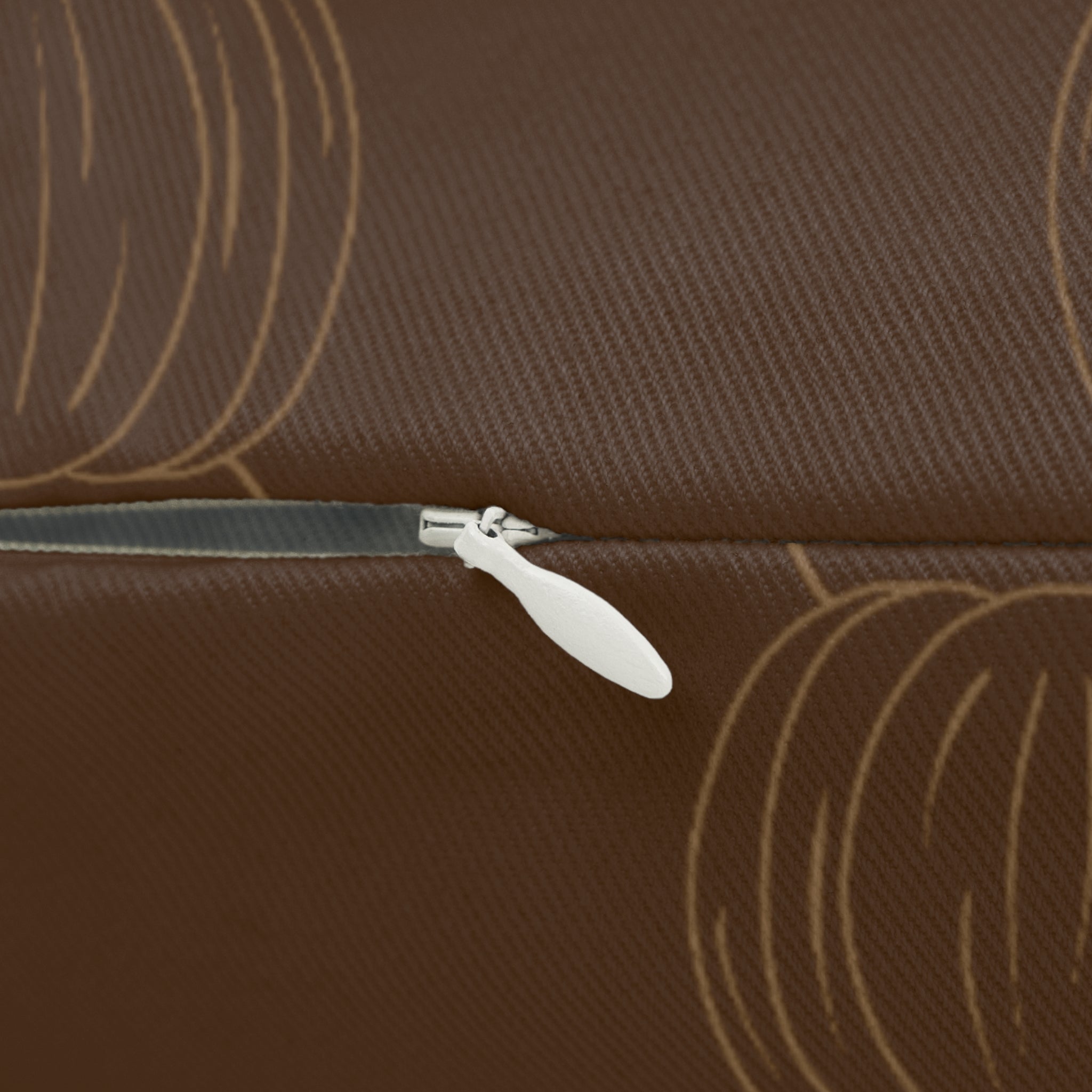 Brown lumbar pillow close-up with tan pumpkin print and visible zipper tab