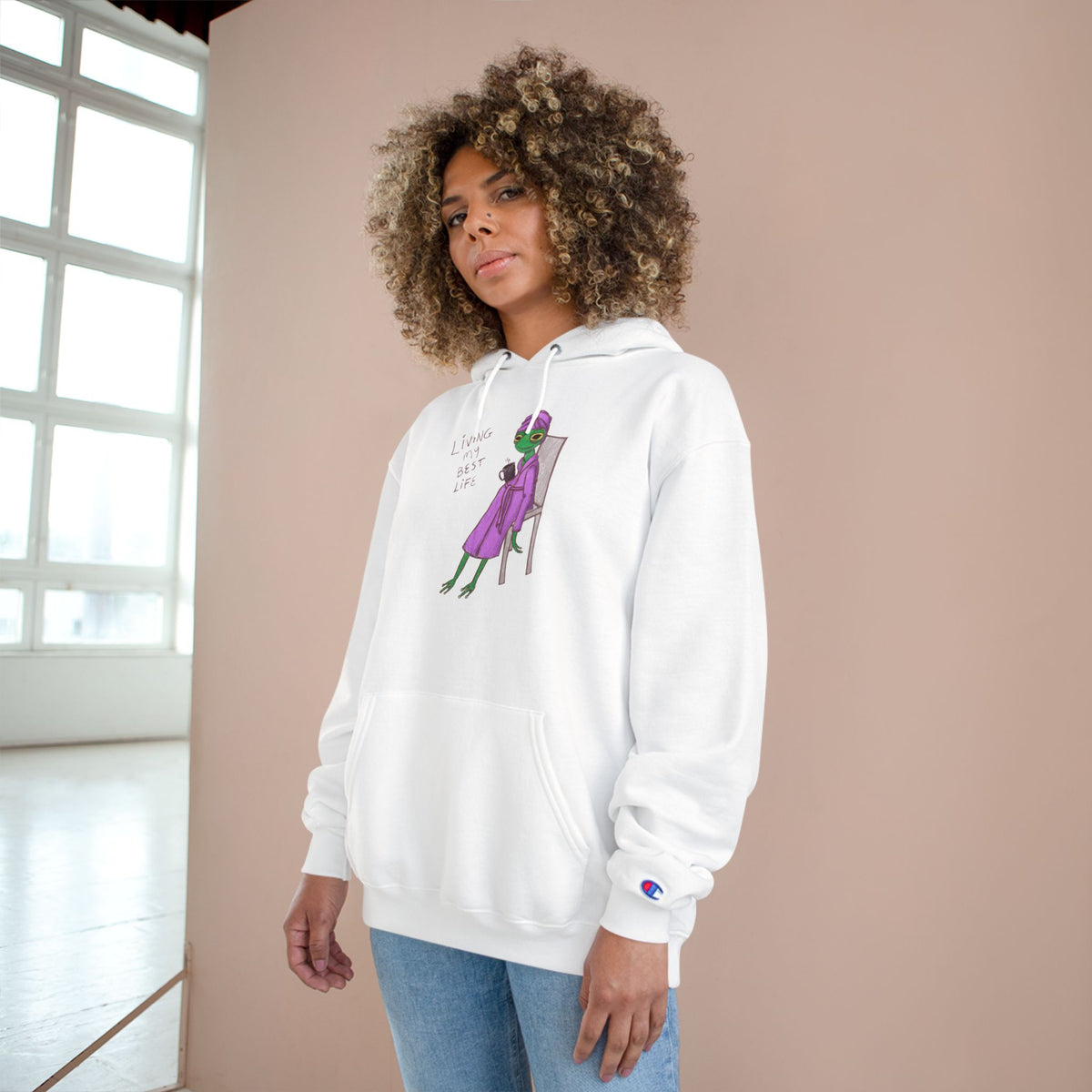 Unisex white hoodie worn by model, front character graphic and drawstring hood