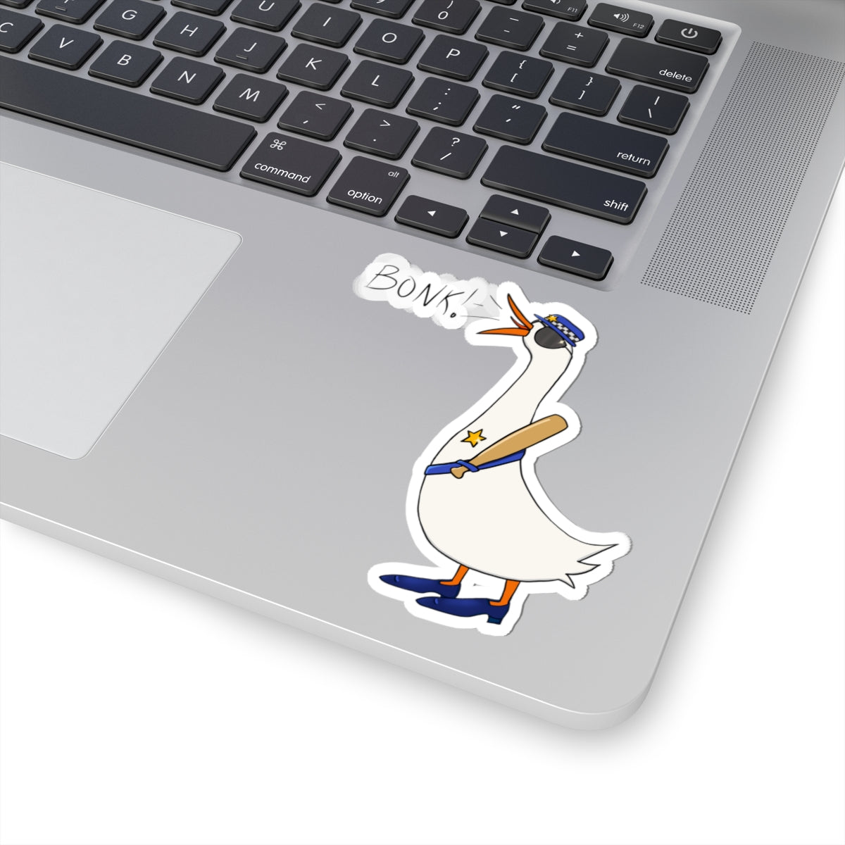 Cartoon goose kiss-cut sticker with “BONK!” text and blue uniform on a laptop lid