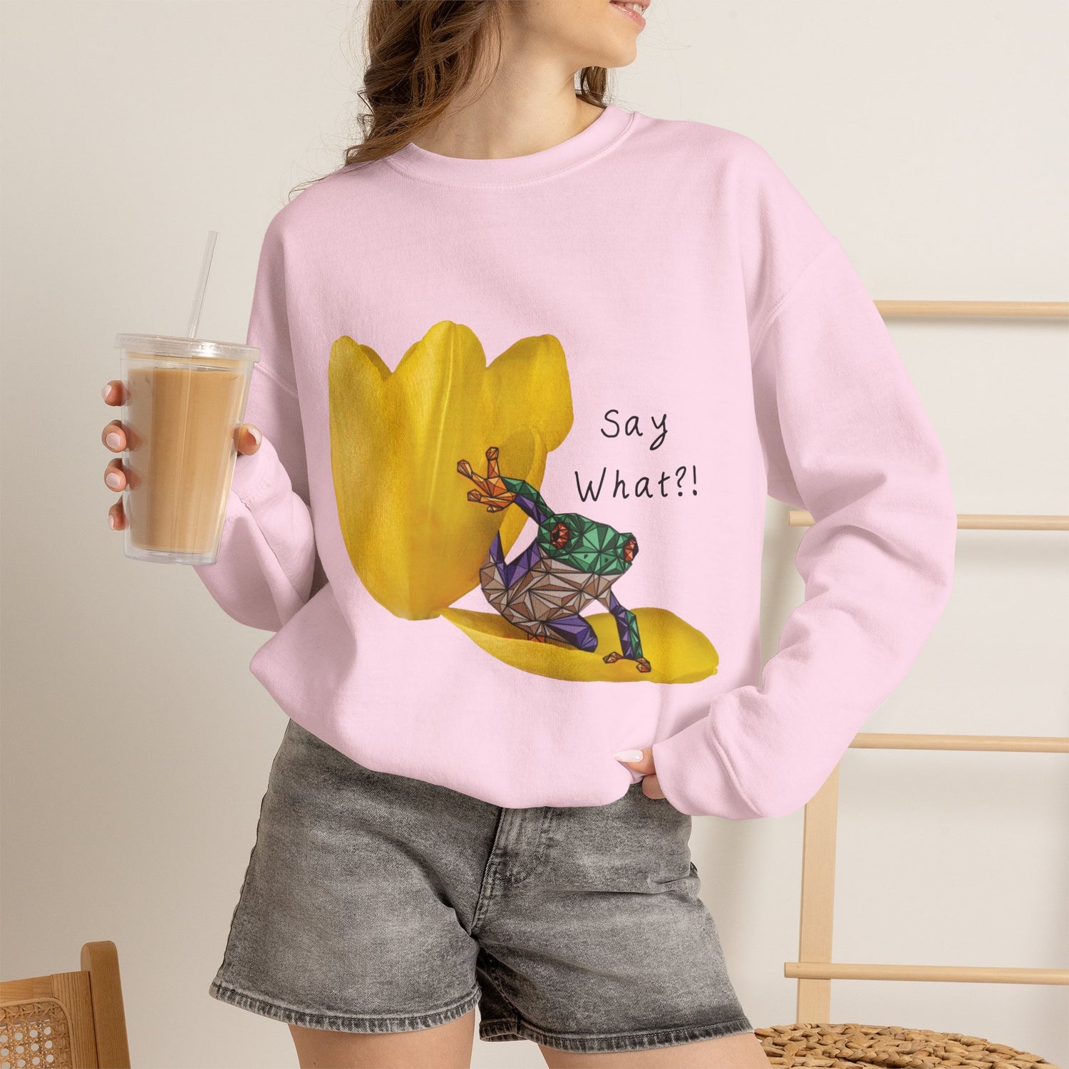 Pink crewneck sweatshirt with yellow tulip frog graphic and “Say What?!” on the front
