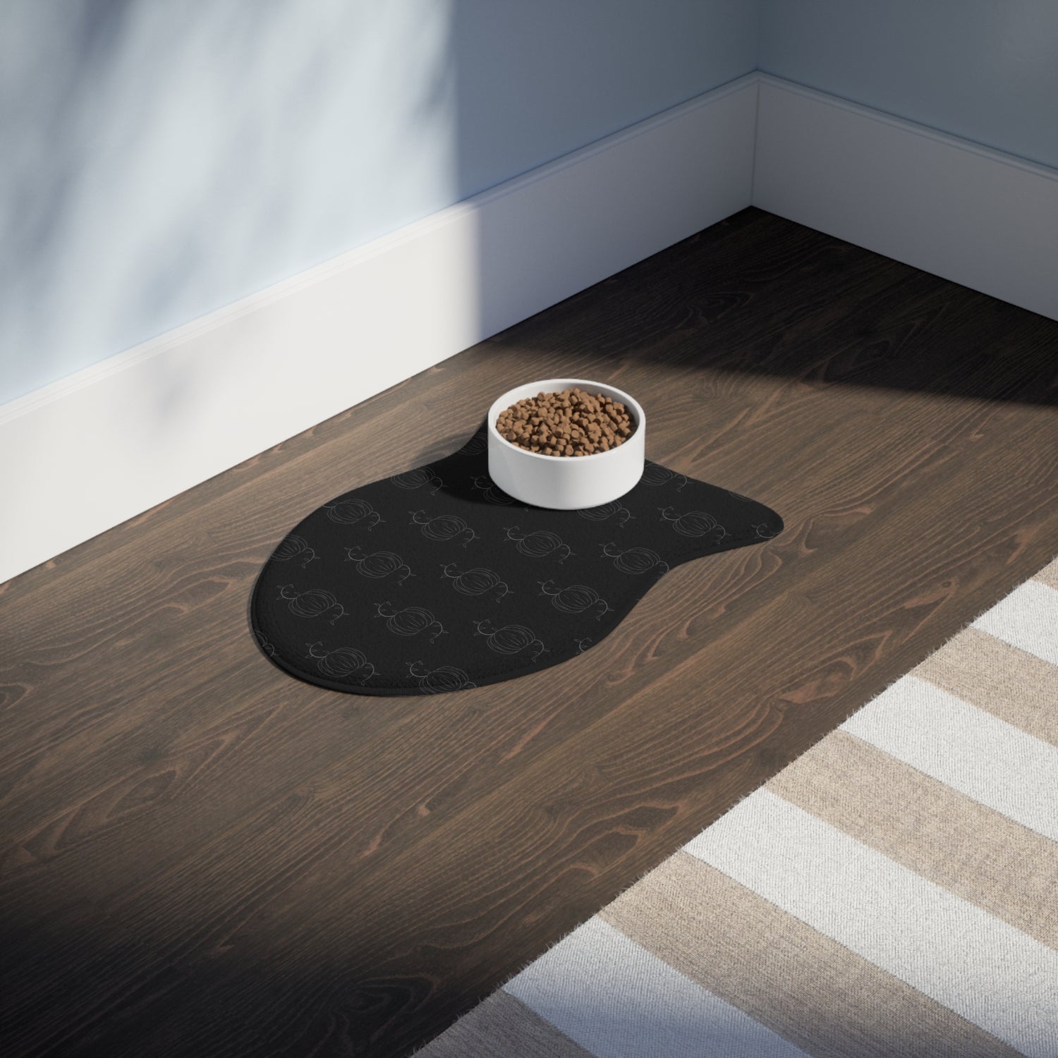 Black pet feeding mat with subtle paw pattern and rounded oval shape