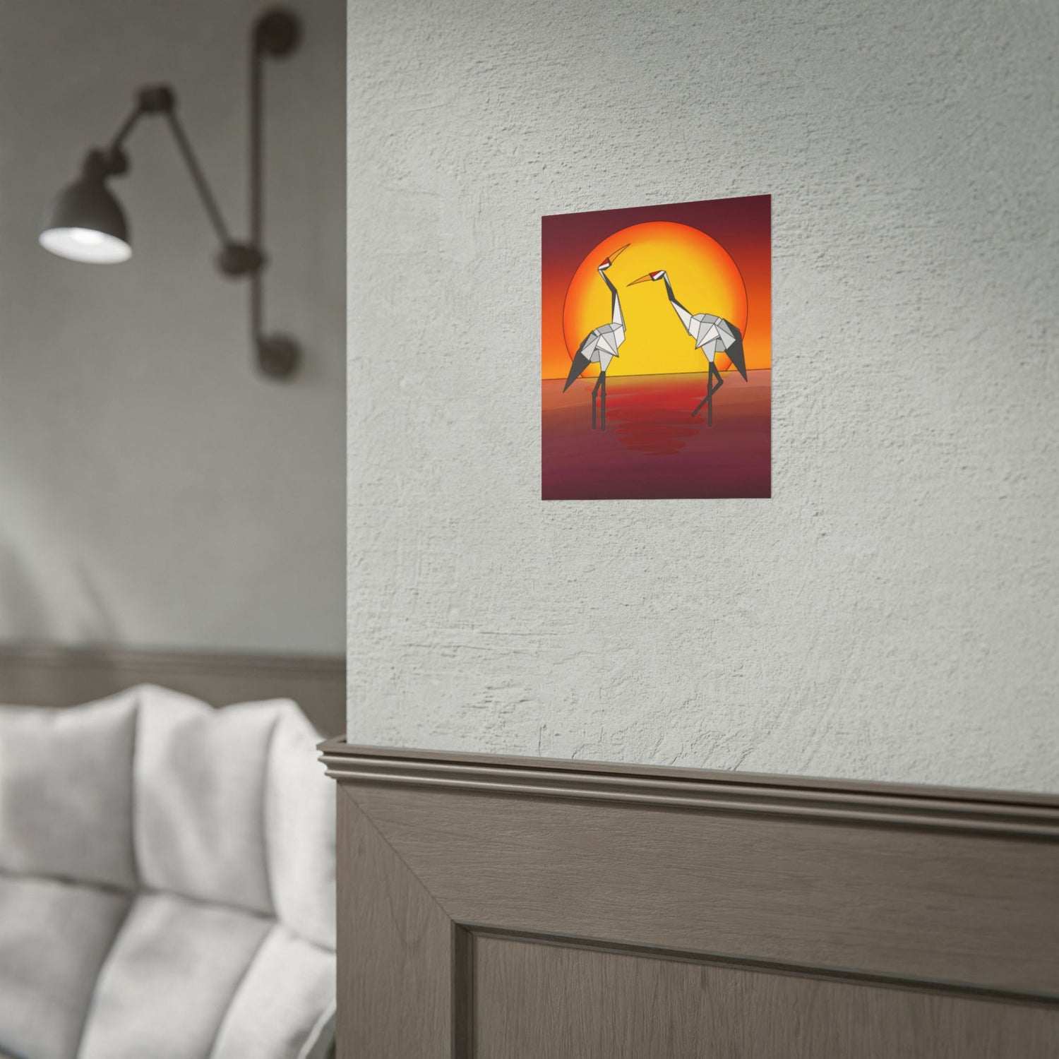 Small sunset poster of two origami cranes framed on a wall