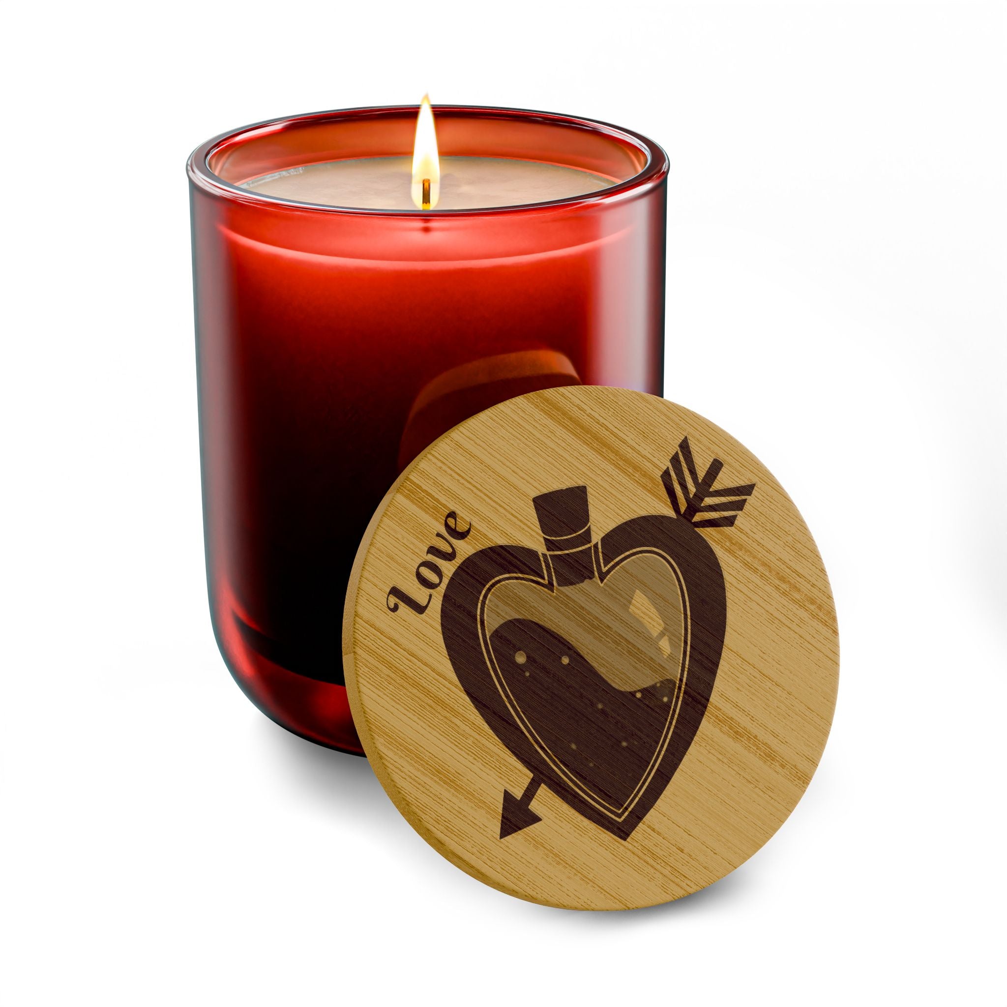 Red tinted soy candle with lit wick and round engraved wooden lid with heart design.