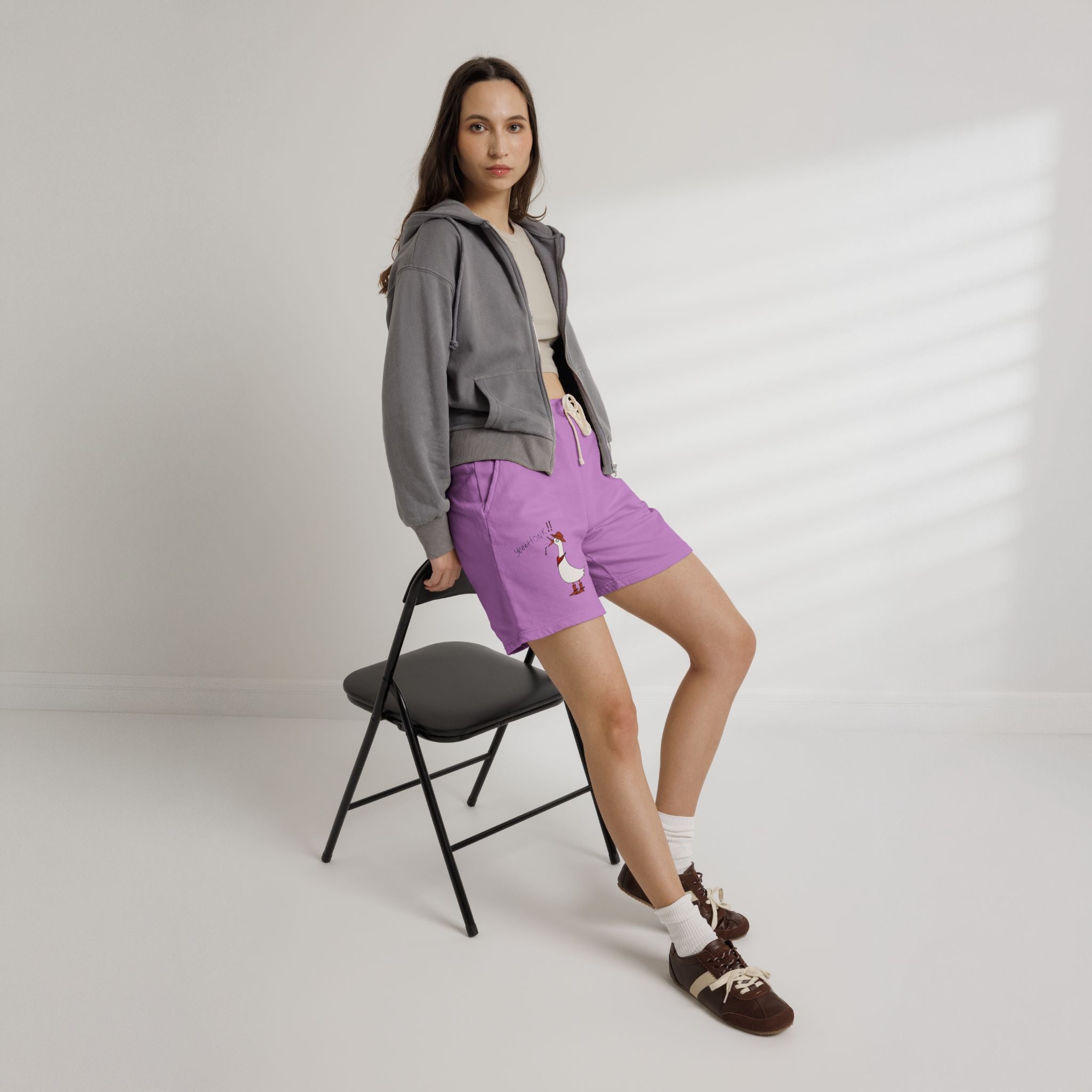 Purple drawstring sweat shorts with cartoon duck graphic on left leg