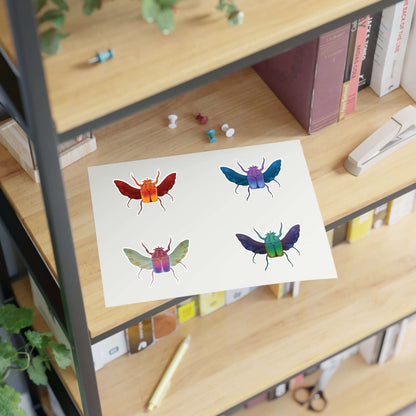 Die-cut sticker sheet with four colorful beetle illustrations on white paper
