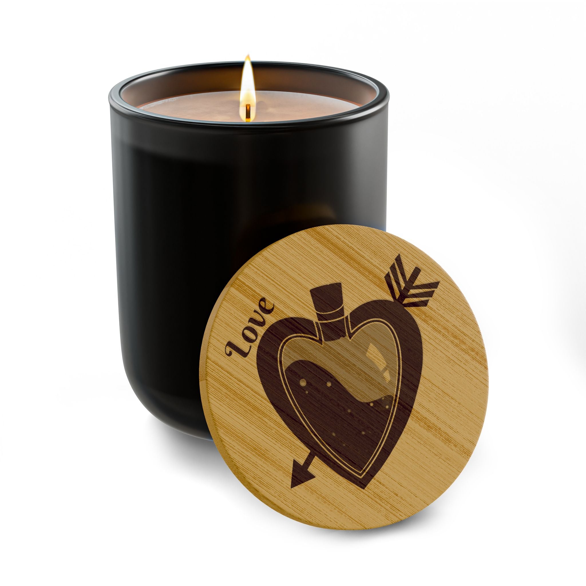 Black soy candle with lit wick and round engraved wooden lid with heart design.