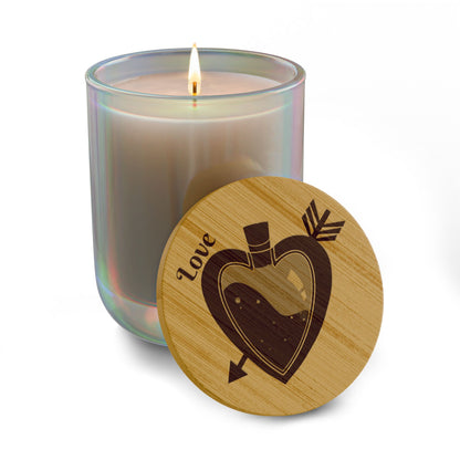 Light cream soy candle with lit wick and round engraved wooden lid with heart design.