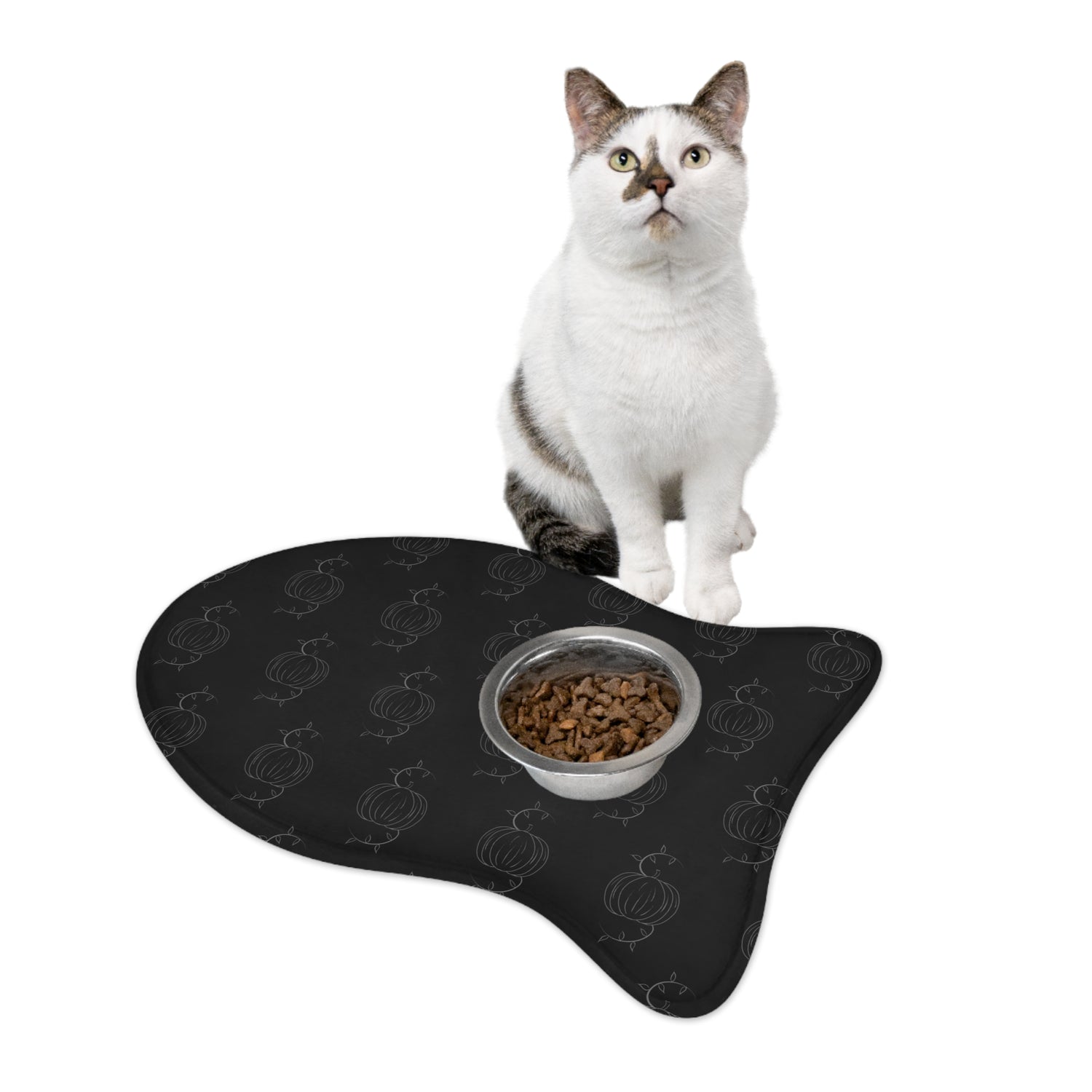 Black pet feeding mat with pumpkin pattern, cat sitting with bowl of kibble