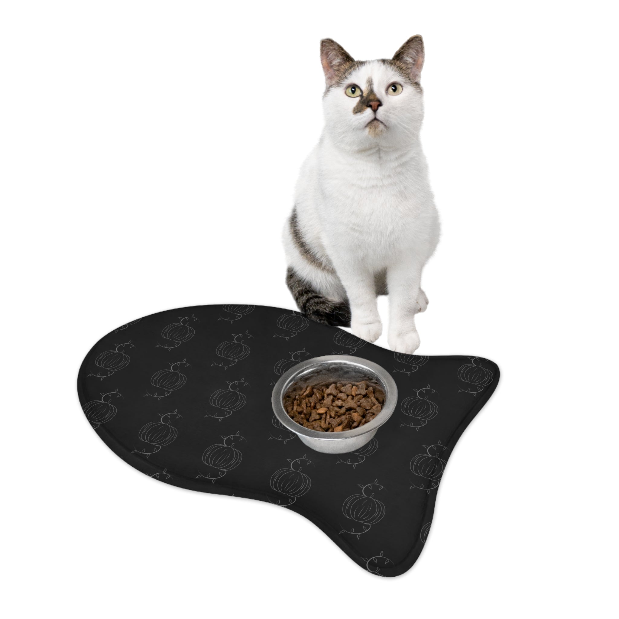 Black pet feeding mat with pumpkin pattern, cat sitting with bowl of kibble