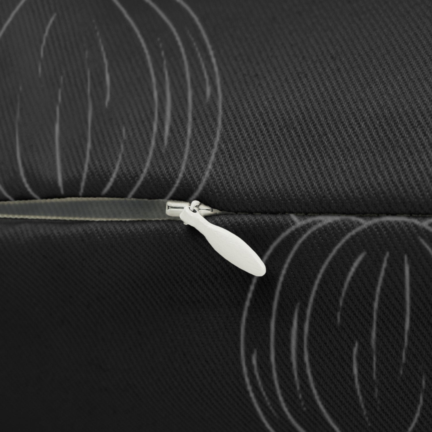 Black lumbar pillow zipper and pumpkin-pattern fabric detail