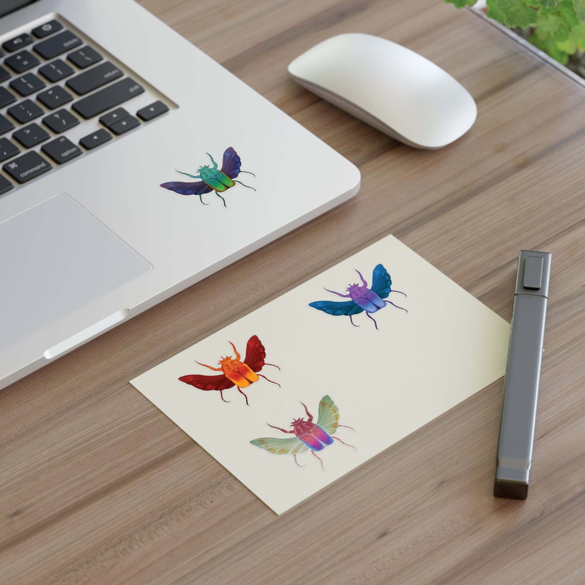 Die-cut sticker sheet with four colorful beetle stickers on white paper