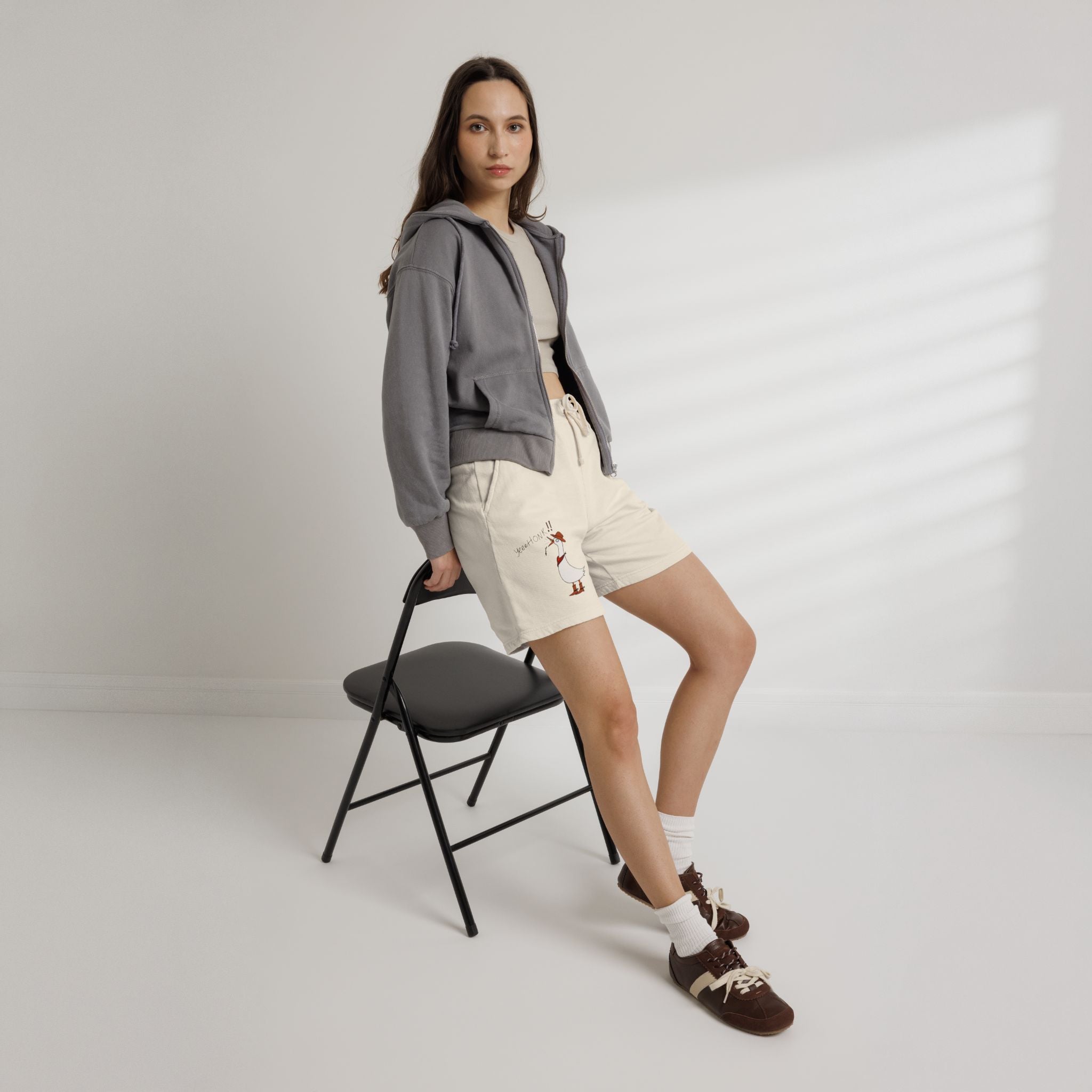 Ivory sweat shorts with drawstring and cartoon goose illustration, worn by model
