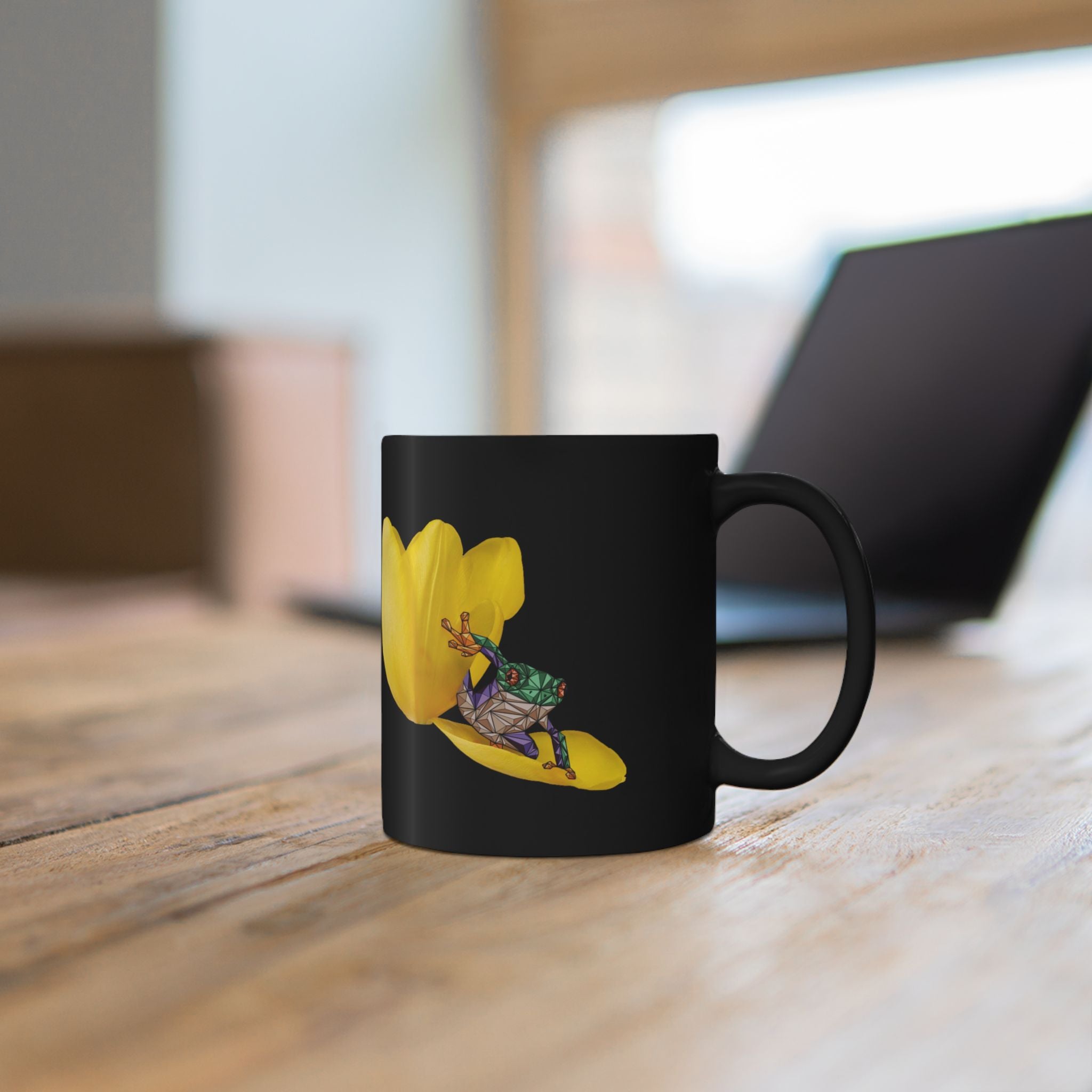 Black ceramic mug with yellow tulip and frog graphic on the front