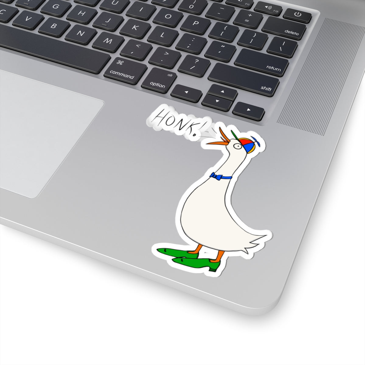 Goose “HONK!” sticker on laptop keyboard, die-cut outline around the character
