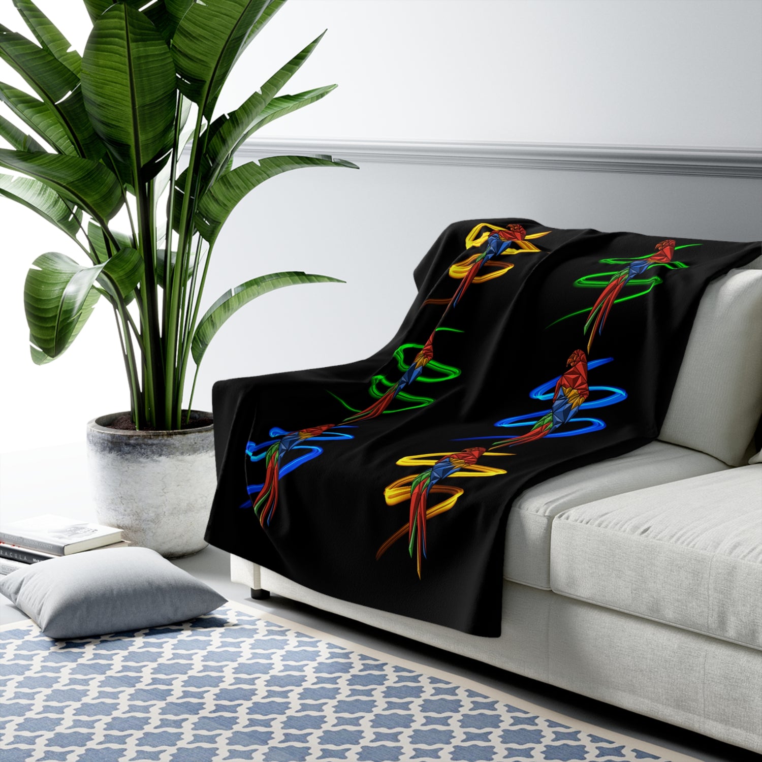 Black parrot spiral sherpa fleece blanket draped with colorful bird motif details