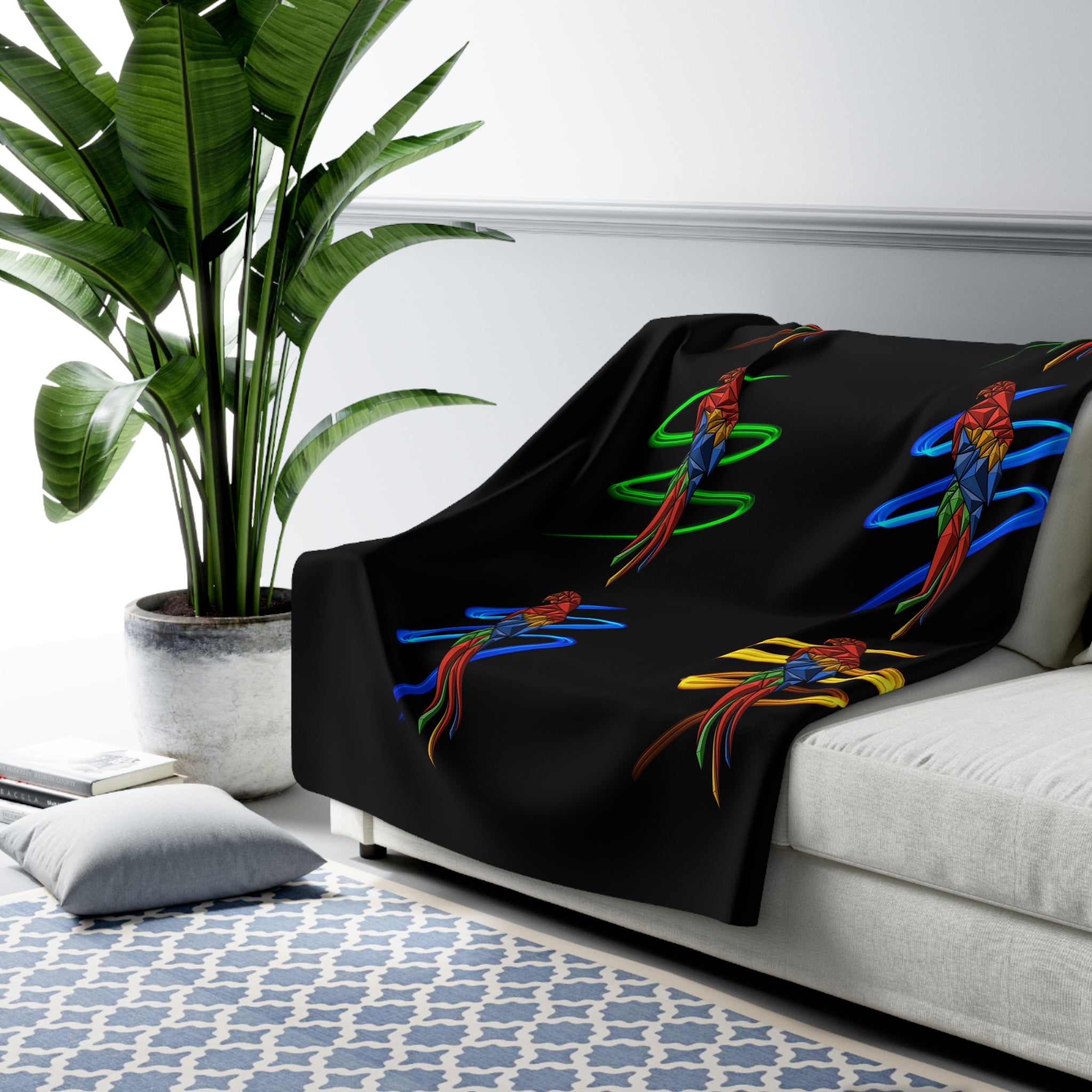 Black sherpa fleece blanket with colorful parrot spiral bird motifs, draped