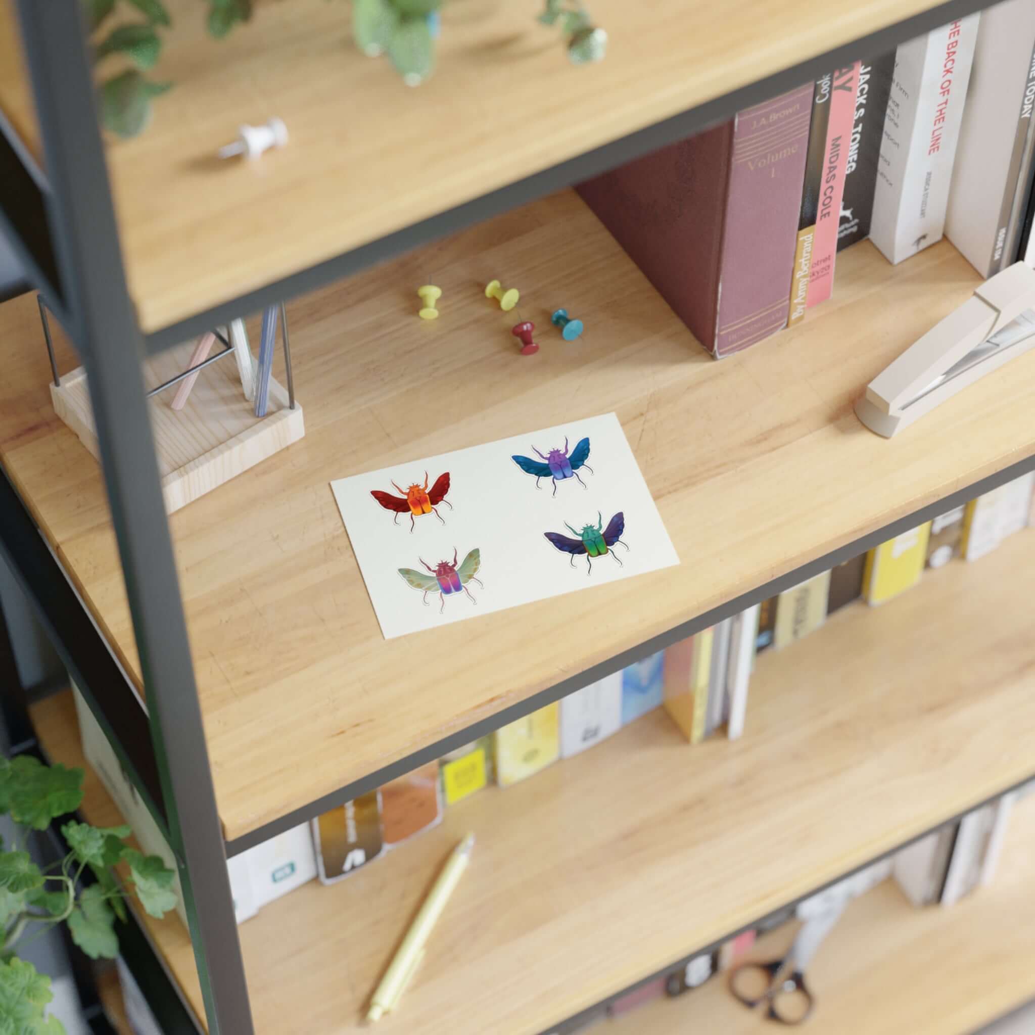 Die-cut sticker sheet with four colorful beetle illustrations on white paper