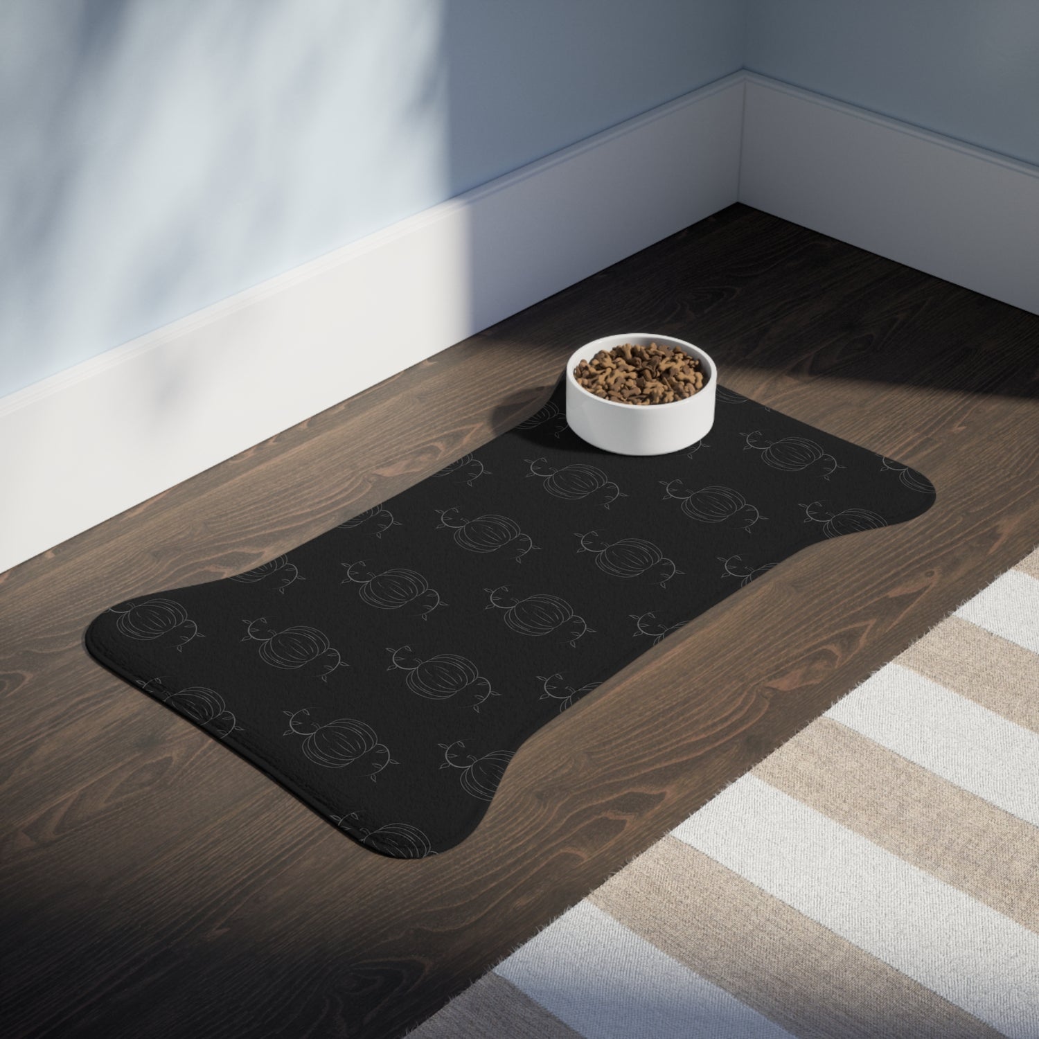 Black pet feeding mat with pumpkin pattern and centered pet-food bowl