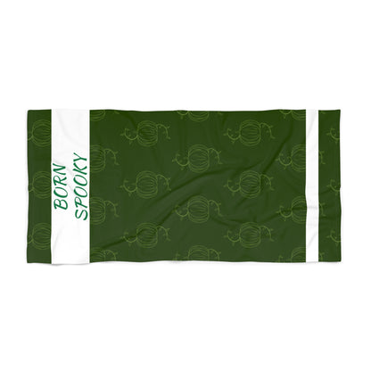 Green pumpkin beach towel featuring repeating pumpkin icons and white bordered stripes