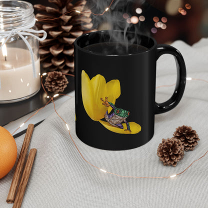 Black ceramic mug with yellow tulip and frog graphic, with steam rising