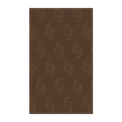 Brown tea towel with repeating pumpkin line pattern, centered front view