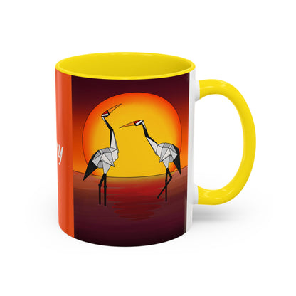 Yellow coffee mug with origami crane scene under a yellow sun circle, with right handle