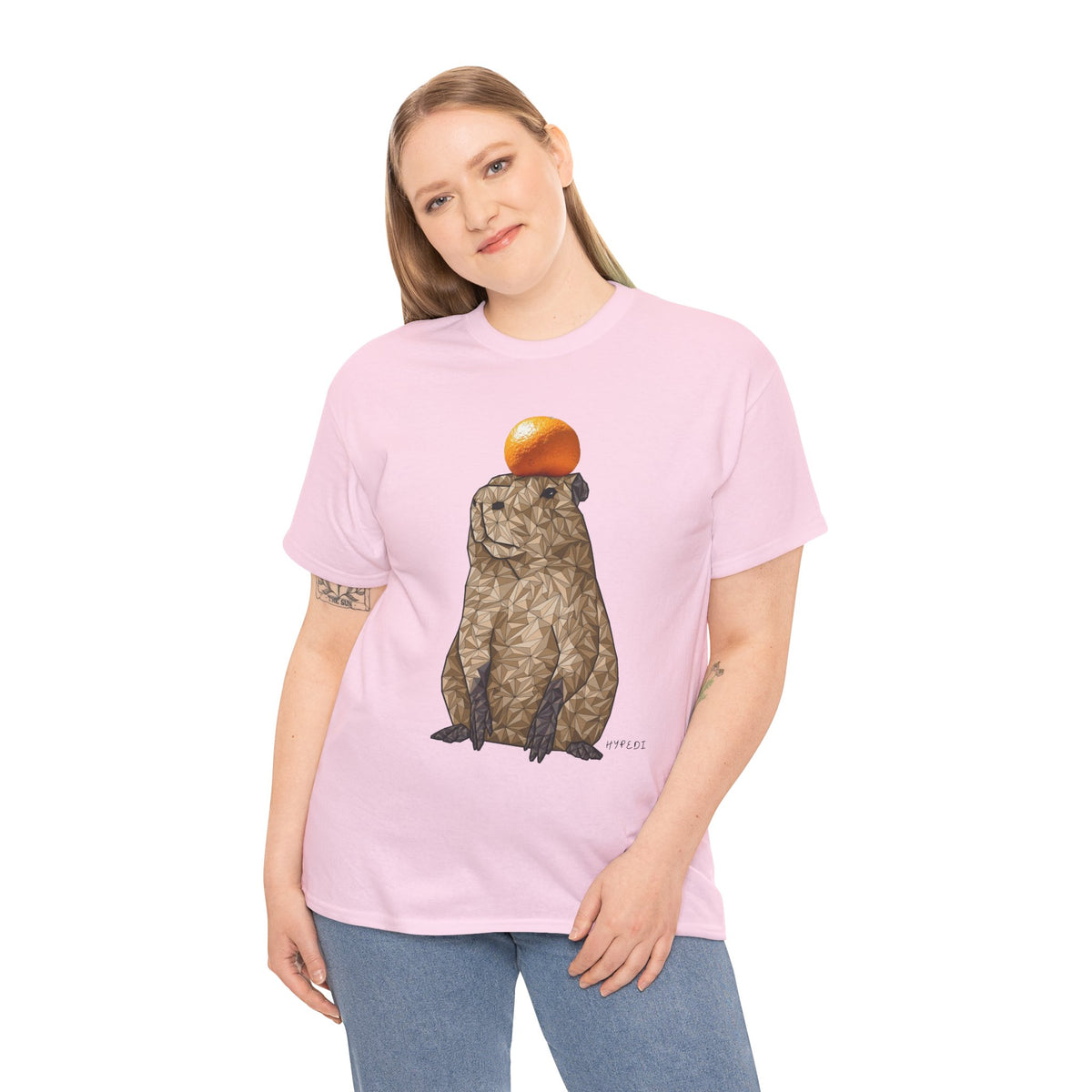 Pink unisex T-shirt with centered capybara graphic holding an orange