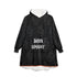 Black hooded blanket with pumpkin motif, front pocket, and "BORN SPOOKY" text