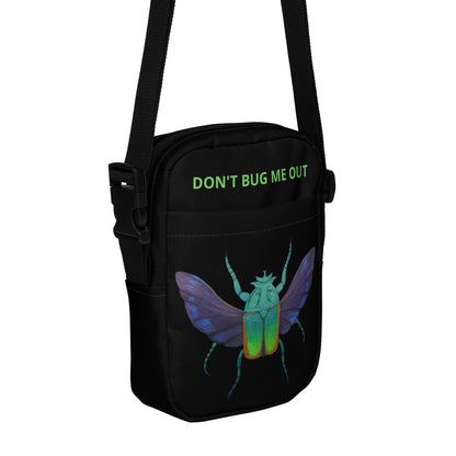 Black utility crossbody bag with green slogan and colorful insect graphic on front