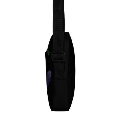 Black utility crossbody bag side view with adjustable strap and front buckle